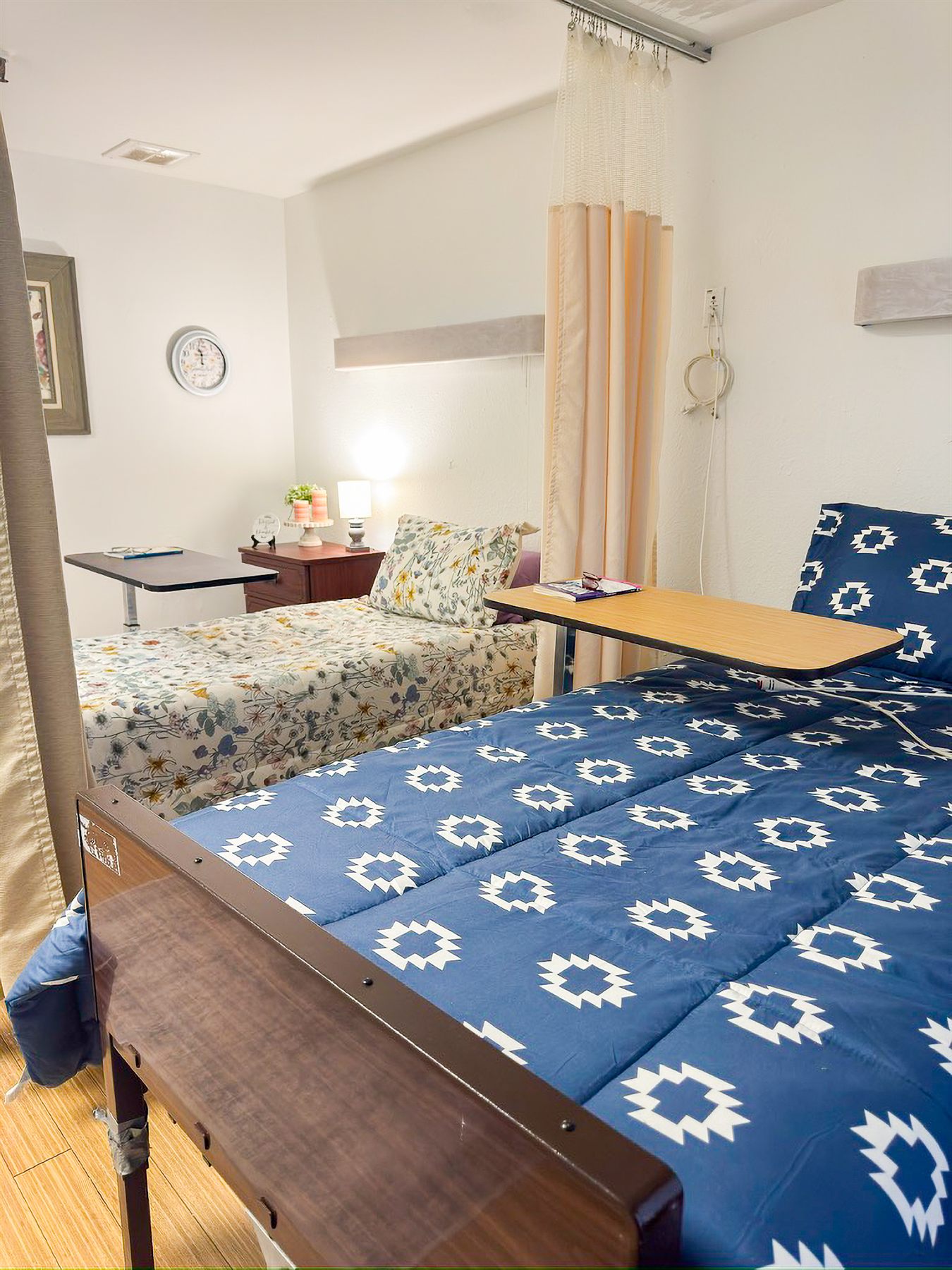 A resident room at Windsor Hills with a blue patterned comforter and personal touches